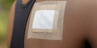 Vrouw met verband en tape op de rug

