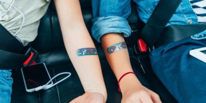 kinderen in een auto met gekleurde pleisters op hun armen
